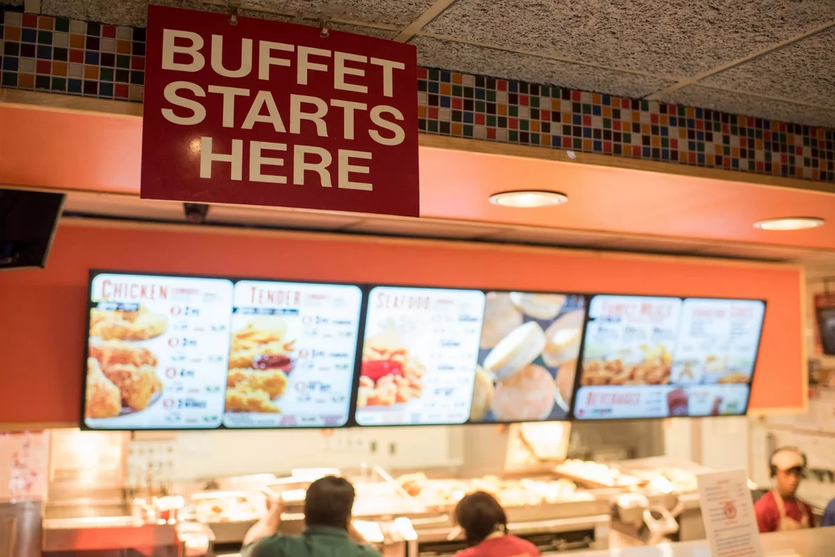A Buffet Starts Here sign hanging above the buffet counter inside a Popeyes restaurant
